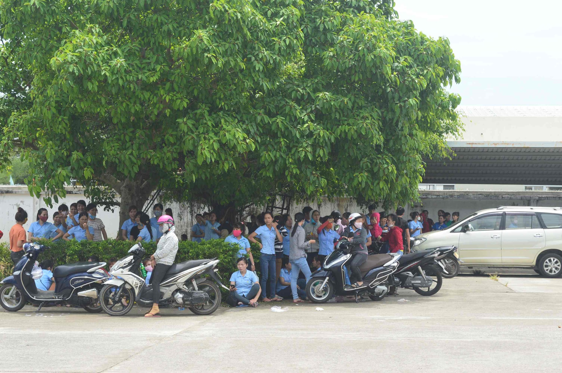 Từng tốp công nhân đình công ra ngoài sân của Công ty TNHH may Minh Hoàng 2 sáng nay. Ảnh: T.L