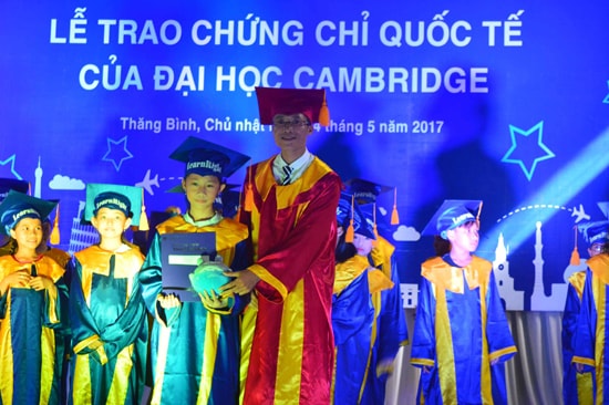 Nguyễn Đức Việt (phải) trao chứng chỉ của Đại học Cambridge cho các học viên của trung tâm. Ảnh: Q.T