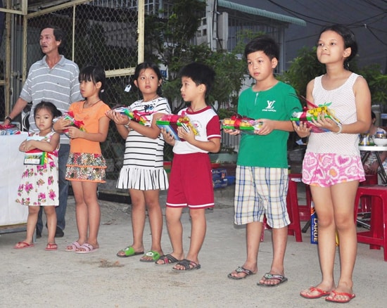 Anh Sơn Mai thay mặt bà con khu phố phát thưởng cho các em.