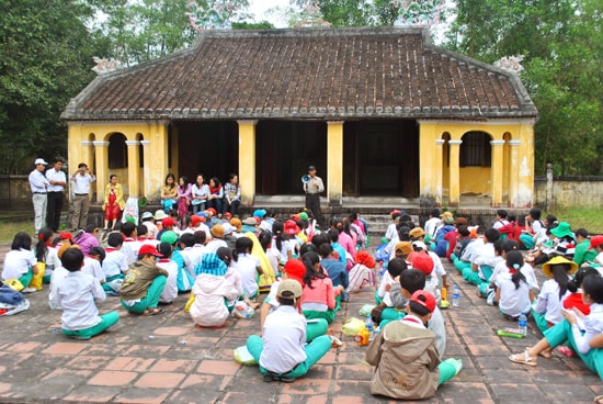 Ông Lê Khắc Phiến (người cầm loa phóng thanh) nói về truyền thống cách mạng của nhân dân xã Kỳ Anh cho các em học sinh. Ảnh: ĐIỆN NGỌC