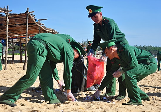 Các chiến sĩ Bộ đội Biên phòng hưởng ứng hoạt động làm sạch bãi biển xã Tam Quang sau lễ ra quân chiến dịch Thanh niên tình nguyện hè 2017. Ảnh: VINH ANH