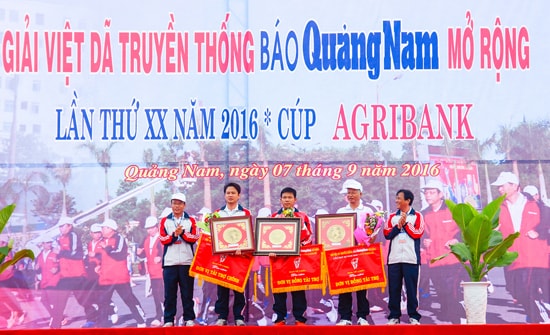 Đại diện Báo Quảng Nam trao cờ lưu niệm cho đơn vị tài trợ chính Agribank Quảng Nam và các đơn vị đồng tài trợ tại giải Việt dã Truyền thống Báo Quảng Nam. Ảnh: PHƯƠNG THẢO