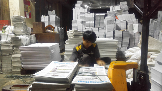 Anh Vân kiểm tra, sắp xếp, phân loại báo Quảng Nam tại Công ty In.