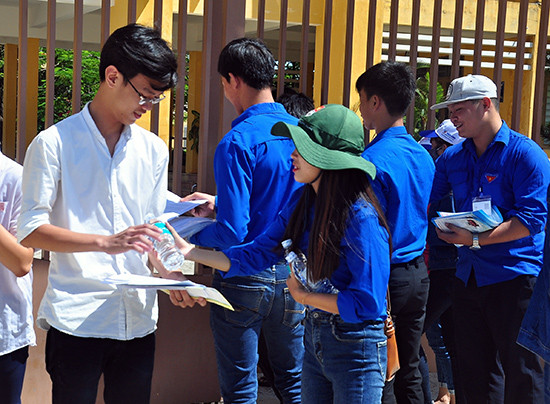 Tình nguyện viên “Tiếp sức mùa thi” phát nước uống miễn phí cho thí sinh tại điểm thi Trường THPT Trần Cao Vân. Ảnh: VINH ANH