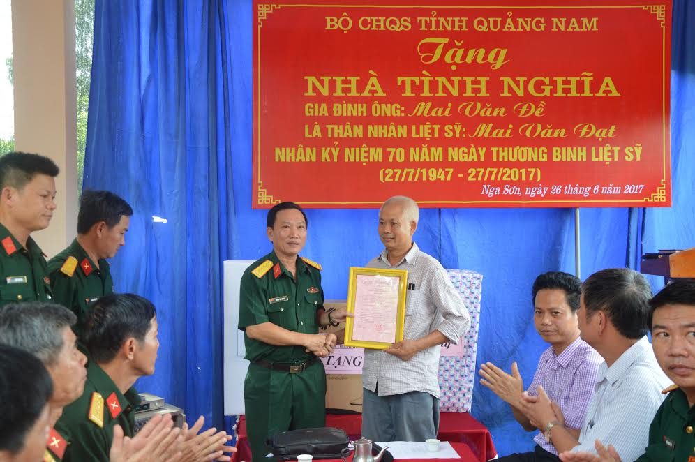 Đại tá Đoàn Thế Tùng, Phó Chính ủy Bộ CHQS tỉnh trao quyết định bàn giao nhà cho gia đình ông Mai Văn Đề.