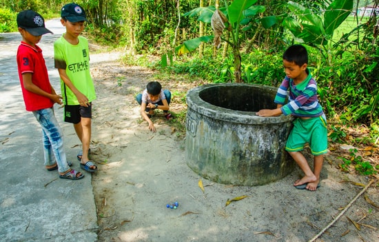 Trẻ em chơi trò bắn bi. Ảnh: PHƯƠNG THẢO