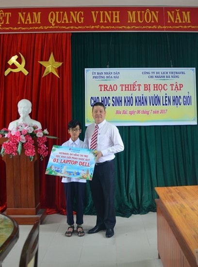 Ông Đoàn Hải Đăng - Giám đốc Chi nhánh Vietravel Đà Nẵng trao quà là một chiếc laptop cho em Phan Ngọc Quý