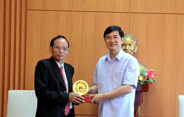 Secretary Quang (right) offers the symbol of Quang Nam’s heritages to Chairman Khammay Duongcannha