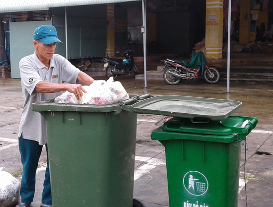 Ông Hoàng Ngọc Tâm đang dọn dẹp vệ sinh khu vực chợ Bình Minh.