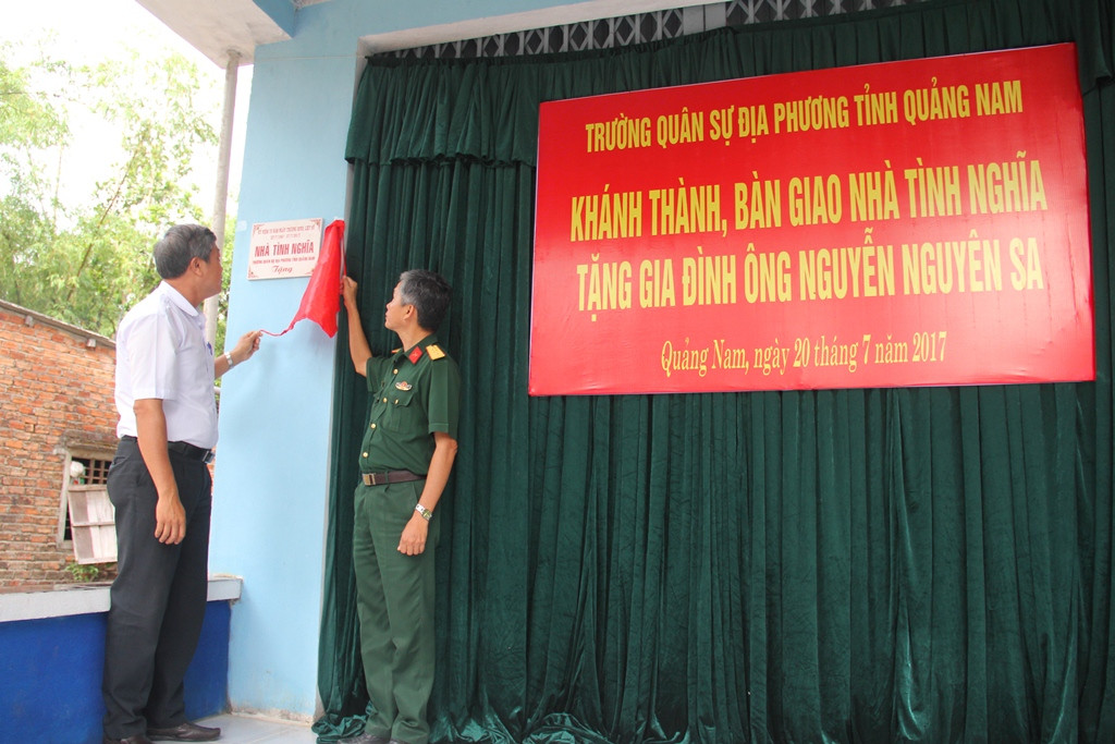 Đại diện chính quyền xã Tam Phú và lãnh đạo Trường Quân sự địa phương tỉnh mở băng khánh thành nhà tình nghĩa. Ảnh: A.N