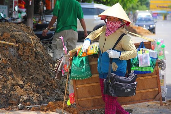 Trưa, nhưng cô Lan (quê Sơn Tịnh, Quảng Ngãi) vẫn đội nắng tranh thủ đến các quán cà phê, quán ăn để bán dạo. “Lúc nào mệt thì nghỉ, lúc nào đói thì kiếm cái gì để ăn, rồi tiếp tục đi bán” - cô Lan chia sẻ về hành trình mưu sinh của mình.