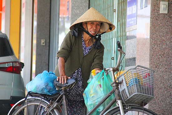 Hơn 13h, nhưng người phụ nữ lớn tuổi này vẫn đi tìm mua ve chai bằng chiếc xe đạp cũ kỹ. Dù cuộc sống mưu sinh vất vả, nhưng bà vẫn lạc quan, nở nụ cười tươi khi phóng viên đề nghị chụp ảnh.