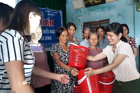 Hội LHPN xã Bình Tú trao giỏ nhựa chứa rác gia đình cho các hội viên phụ nữ.Ảnh: BIÊN SƯƠNG