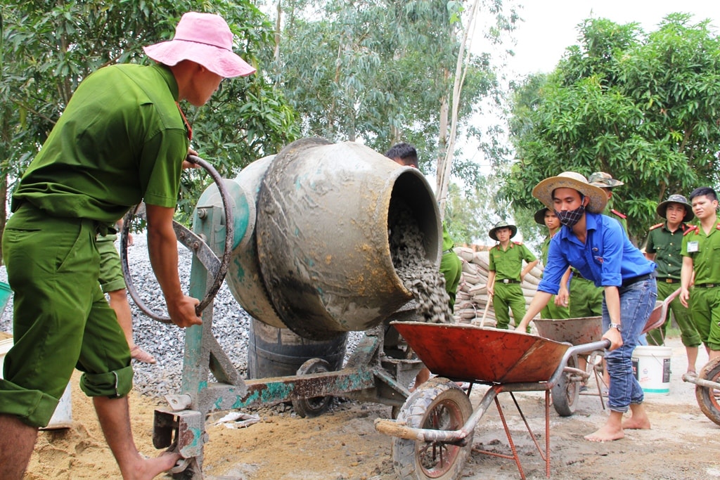 Bên cạnh sức người, các chiến sĩ công an phải sử dụng thêm máy trộn bê tông để làm đường. Ảnh: V.A