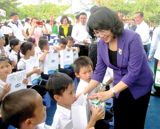 Phó Chủ tịch nước Đặng Thị Ngọc Thịnh trao sữa cho các em học sinh ở xã Duy Trinh, huyện Duy Xuyên. Ảnh: THÀNH SỰ