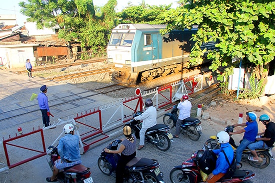 Các nhân viên gác chắn làm nhiệm vụ đón tàu chạy qua.