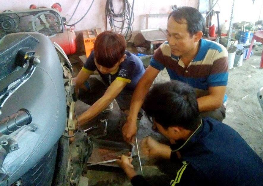 Anh Sơn bày vẽ cho các thanh niên trong tiệm sửa xe của mình.