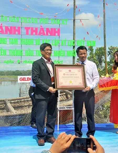Ông Nguyễn Minh Nam (phải) đón nhận bằng kỷ lục con đường thuyền thúng đầu tiên và nhiều nhất Việt Nam. Ảnh: N.A