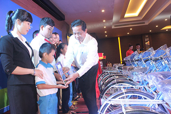 Ông Đặng Thuần Phong - Phó Chủ nhiệm Ủy ban các vấn đề xã hội của Quốc hội trao học bổng những chiếc xe đạp và ba lô tiếp thêm động lực cho học sinh nghèo của tỉnh. Ảnh: L.D