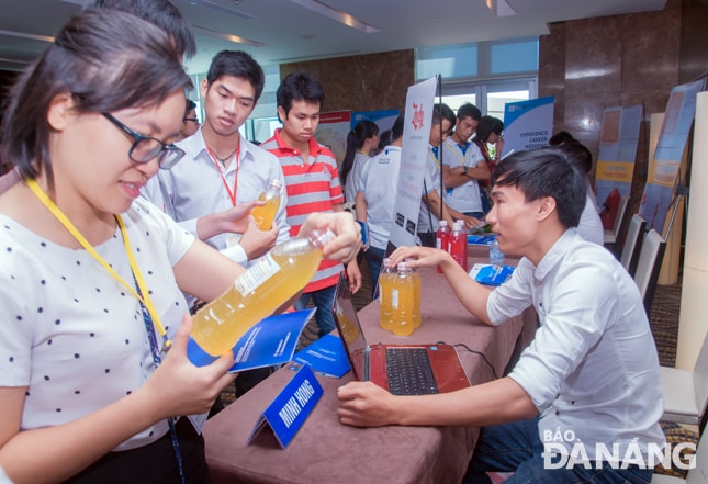 Khách hàng tìm hiểu sản phẩm nước rửa chén sinh học của dự án khởi nghiệp Minh Hồng.    Ảnh: KHANG NINH