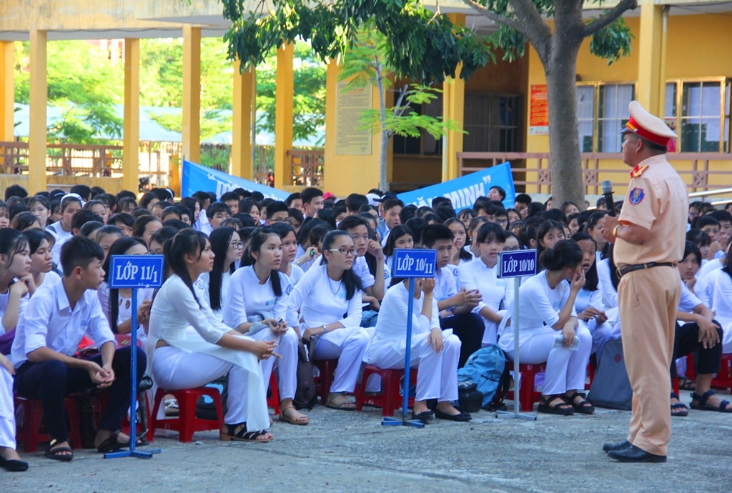 Các em học sinh chăm chú lắng nghe các chiến sĩ CSGT tuyên truyền nhằm trang bị cho bản thân những kiến thức cần thiết về an toàn giao thông. Ảnh: ALĂNG NGƯỚC