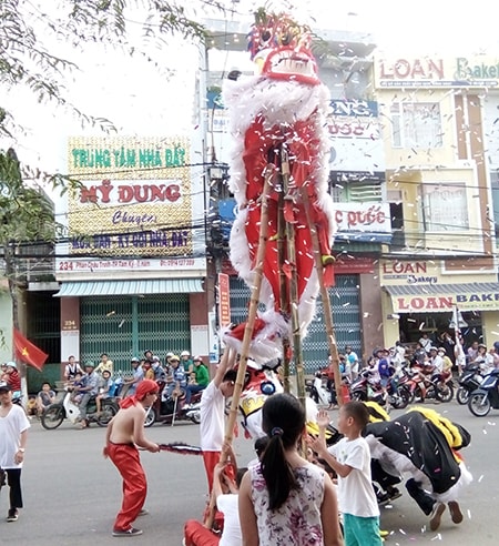 Múa lân dưới lòng đường và phun kim tuyến gây mất an toàn giao thông và an toàn điện. Ảnh: CHÂU NỮ