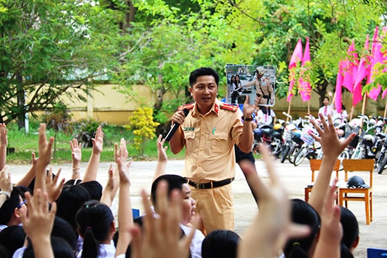 Học sinh hào hứng với cách tuyên truyền ngoại khóa hấp dẫn, sinh động của lực lượng CSGT trong trường học. Ảnh: T.C