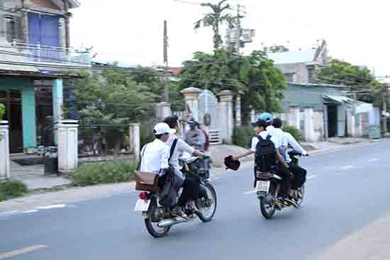 Học sinh không đội mũ bảo hiểm; riêng xe phân khối lớn còn chở 3, đùa giỡn trên đường.