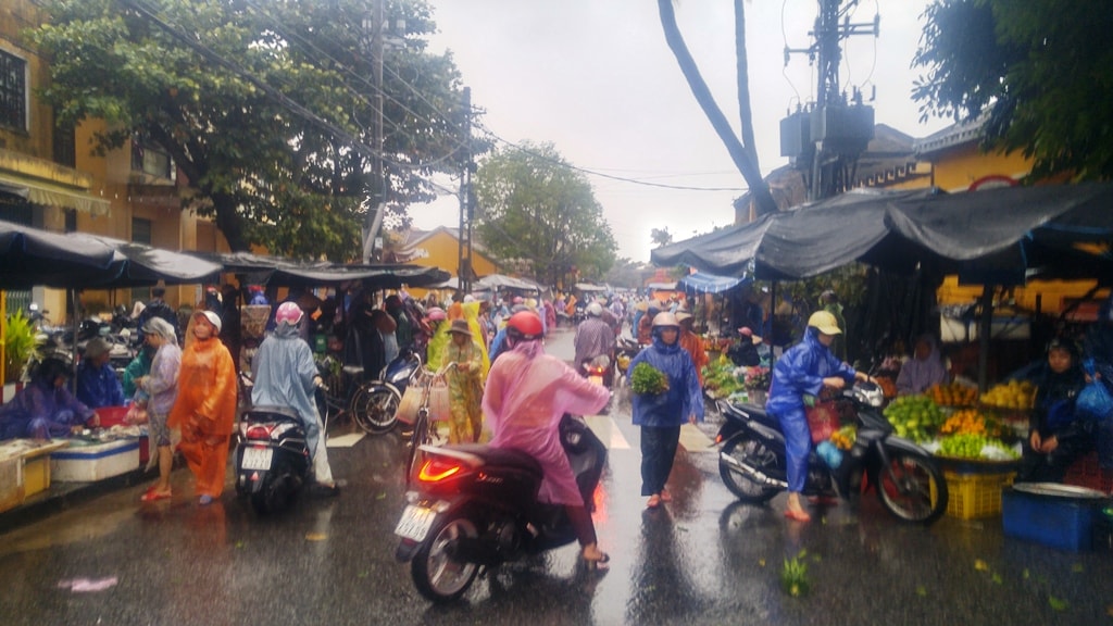 Chợ bị ngập, nên người dân dời lên chỗ cao hơn để buôn bán. Ảnh: XUÂN THỌ