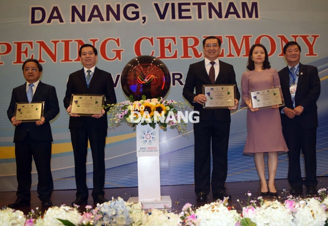 Ban tổ chức quốc tế VOF Tổ chức Diễn đàn tiếng nói tương lai APEC 2017 trao tặng Kỷ niệm chương đến (từ trái qua phải) GS. TS Trần Văn Nam, Giám đốc Đại học Đà Nẵng; Bí thư T.Ư Đoàn TNCS Hồ Chí Minh Nguyễn Long Hải; Chủ tịch UBND thành phố Đà Nẵng Huỳnh Đức Thơ và đại diện tập thể Trường Đại học Đà Nẵng.