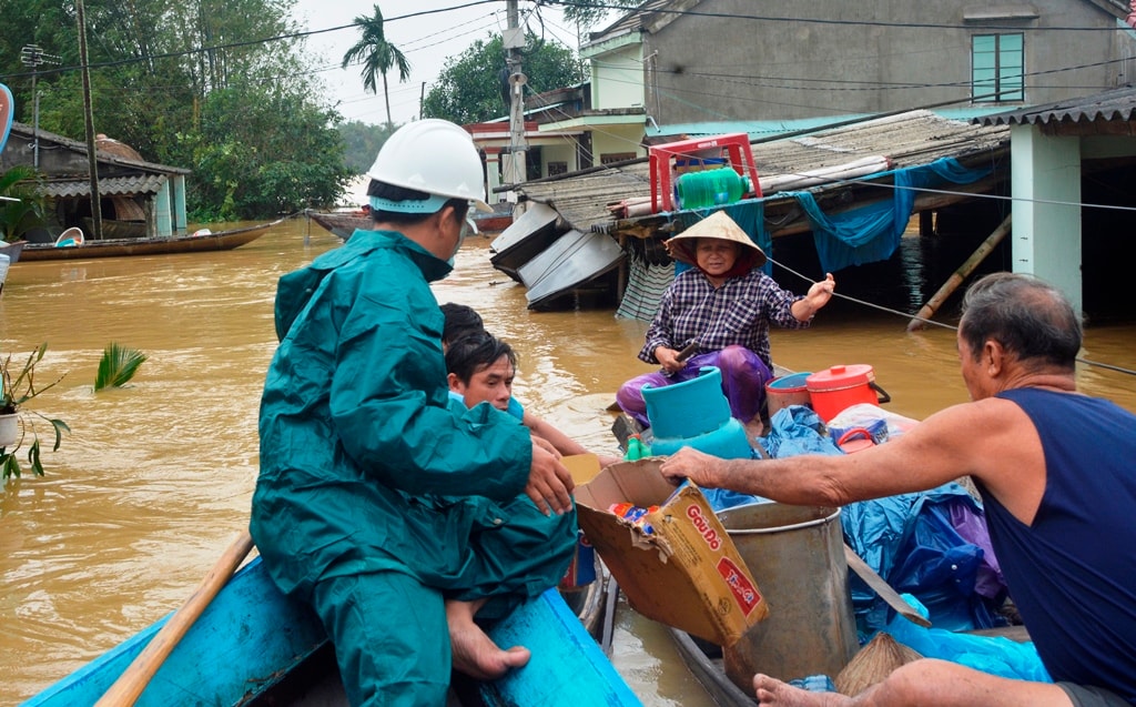 Người dân phường Thanh Hà nhận cứu trợ từ các lực lượng chức năng. Ảnh: XUÂN THỌ