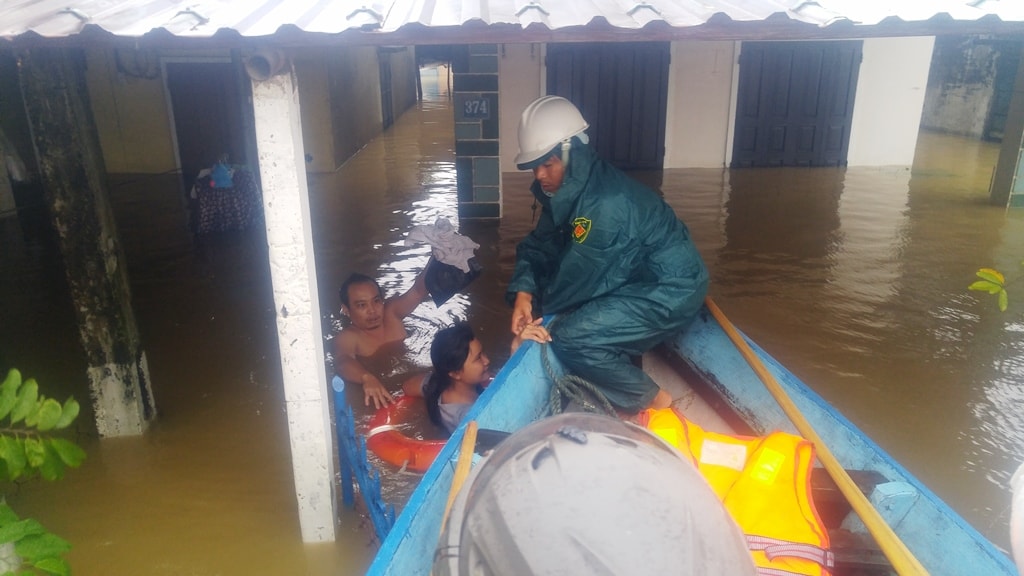 Đưa người dân lên thuyền cứu hộ. Ảnh: XUÂN THỌ