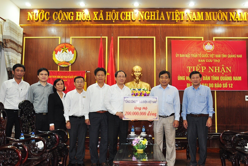 Đoàn cứu trợ của Tổng Công ty Bưu điện Việt Nam trao biển tượng trưng hỗ trợ 200 triệu đồng cho nhân dân Quảng Nam. Ảnh: V.H 