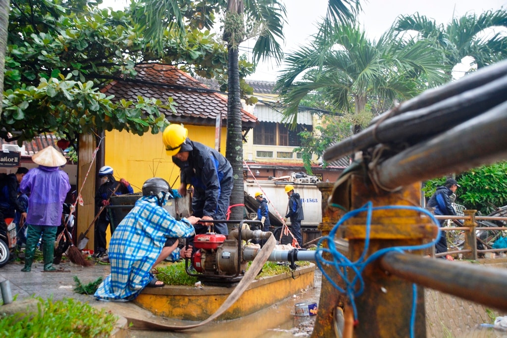 Nổ máy bơm nước để xịt rửa bùn đất. Ảnh: XUÂN THỌ