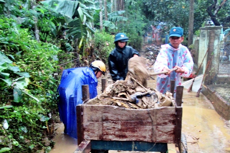 Lực lượng dân quân xã Duy Sơn thu dọn bùn đất trước cổng Trường Mẫu giáo Duy Sơn sáng nay 8.11. Ảnh: THÀNH SỰ