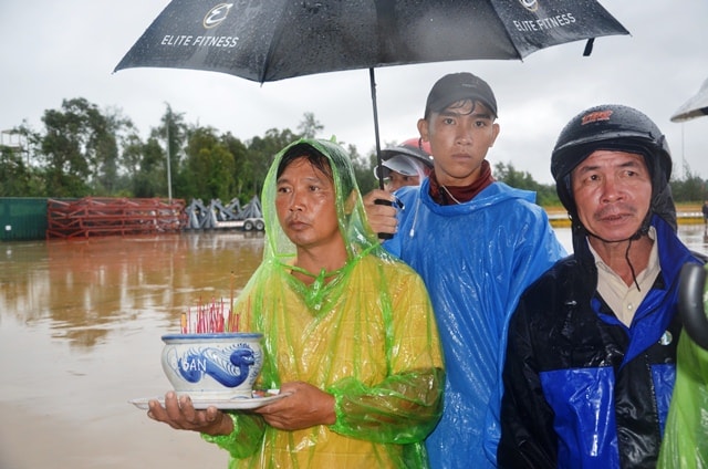 Ngư dân Nguyễn Văn Công cầm bình hương trước quan tài người anh trai của mình. Ảnh: PHÚC VIỆT