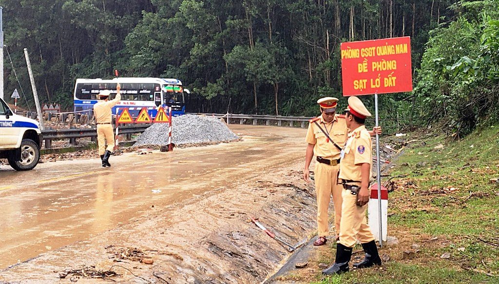 Lực lượng CSGT cắm biển cảnh báo sạt lở trên tuyến đường Hồ Chí Minh. Ảnh: CA cung cấp