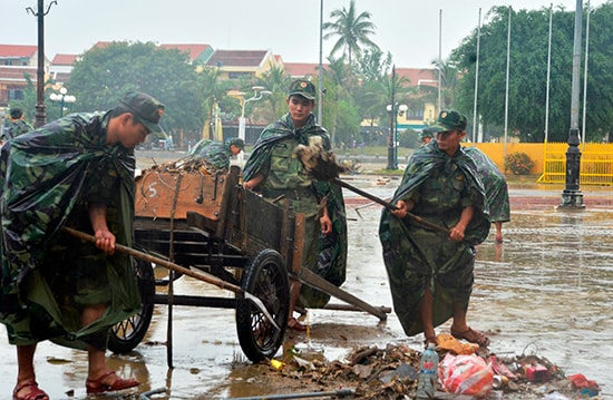 Cán bộ, chiến sĩ lực lượng vũ trang tham gia dọn dẹp ở phố cổ sau lũ. Ảnh: XUÂN THỌ