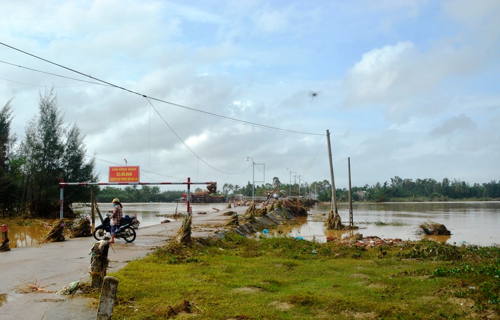 Để đảm bảo an toàn tính mạng cho người dân, chính quyền xã Duy Vinh đã để biến cấm qua lại cầu, tuy nhiên không ít người đã bất chấp để qua lại hai bên cầu. Ảnh: XUÂN THỌ