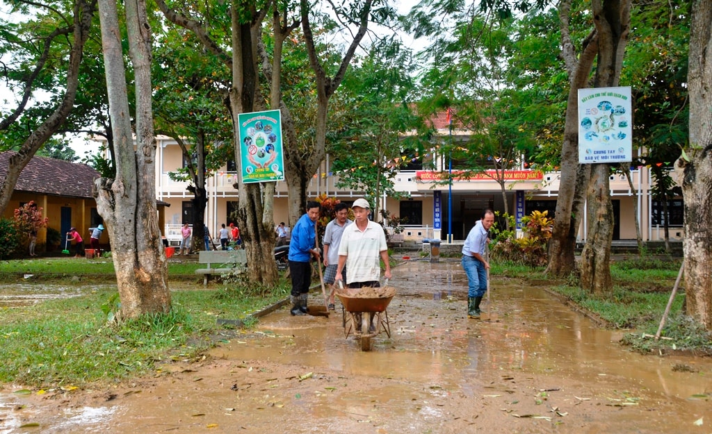 Bùn non bám đầy, thầy cô Trường THCS Lý Thường Kiệt (xã Cẩm Kim) phải dùng xe rùa để di chuyển đi nơi khác. Ảnh: XUÂN THỌ