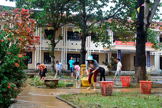 Thầy cô Trường THCS Lý Thường Kiệt (xã Cẩm Kim, TP.Hội An) dọn vệ sinh sau lũ. Ảnh: XUÂN THỌ