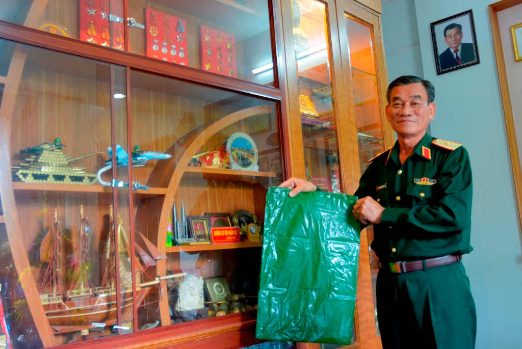 Thiếu tướng Hoàng với chiếc túi nhựa để bảo vệ đồ đạc khỏi bị ướt khi vận chuyển từ tàu vào đảo Trường Sa. Ảnh: XUÂN THỌ
