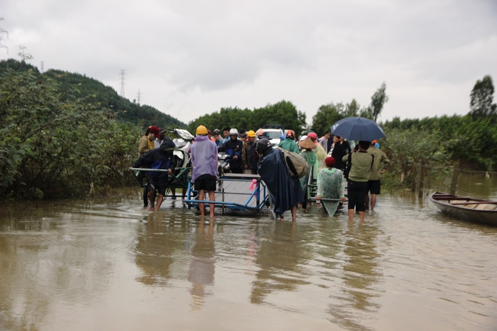 Người dân sử dụng xe bò trung chuyển xe máy qua một đoạn ngập sâu thuộc xã Đại Đồng (huyện Đại Lộc). Ảnh: T.Đ