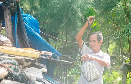 Ông Trúc sửa sang lại mái lều ở Cồn Doi.