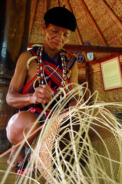 Một già làng thôn Bhơ Hôồng (xã Sông Kôn, huyện Đông Giang) với chiếc gùi sắp thành hình.