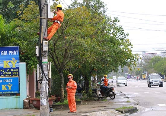 Nhân viên Điện lực Tam Kỳ lắp đặt công tơ mới cho khách hàng. Ảnh: T.L