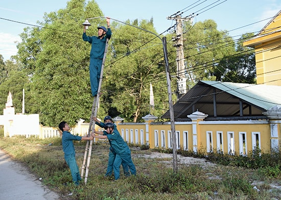 Lực lượng dân quân thường trực xã Bình Nam tham gia mô hình “Thắp sáng đường quê” trên địa bàn xã. Ảnh: VĂN TOÀN