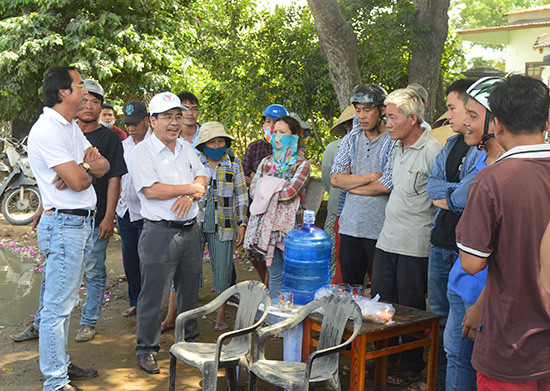 Ông Phan Minh Dũng - Phó Chủ tịch UBND thị xã Điện Bàn (đội mũ vải) đối thoại với người dân địa phương về những vướng mắc trong thi công nâng cấp, mở rộng tuyến ĐT607. Ảnh NGUYÊN ĐOAN