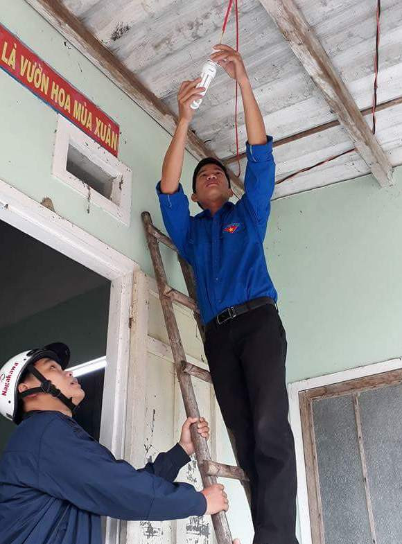 Các ĐVTN huyện Thăng Bình tiến hành sửa chữa điện cho người dân xã Bình Đào - Ảnh: HĐTB