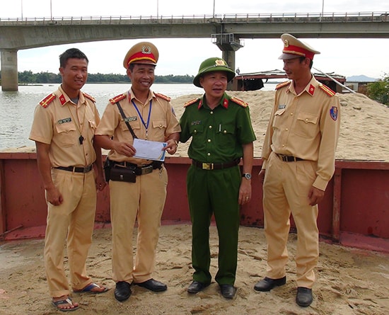 Đại úy Lê Phan Minh Mẫn (thứ hai từ trái qua) cùng cán bộ chiến sĩ Đội Cảnh sát đường thủy trong một lần được Ban giám đốc Công an tỉnh thưởng nóng về thành tích truy bắt tàu hút cát trái phép. Ảnh: X.M